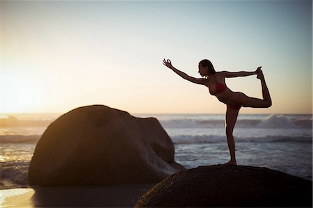 simsearch:6109-08830606,k - Woman performing stretching exercise on beach Fotografie stock - Premium Royalty-Free, Codice: 6109-08952995