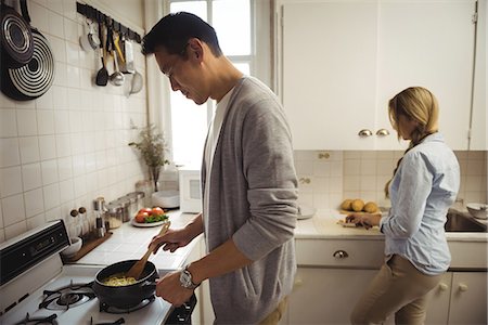 simsearch:6109-08953041,k - Couple preparing food in the kitchen Stockbilder - Premium RF Lizenzfrei, Bildnummer: 6109-08953041