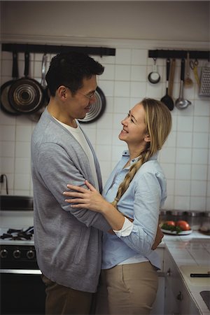 simsearch:6109-08944593,k - Couple embracing each other in kitchen Stock Photo - Premium Royalty-Free, Code: 6109-08953044