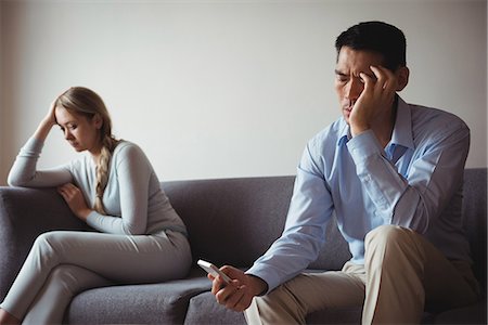 depressive - Couple sitting on sofa and ignoring each other Stock Photo - Premium Royalty-Free, Code: 6109-08953054