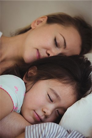 simsearch:6128-08728388,k - Mother and daughter sleeping together in bedroom Stock Photo - Premium Royalty-Free, Code: 6109-08953094