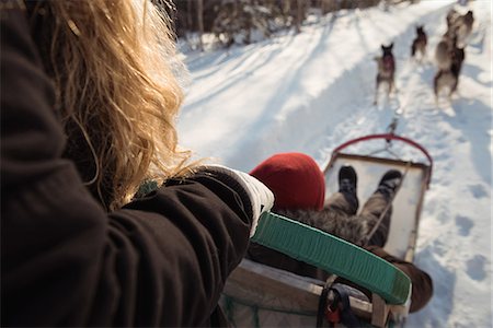 simsearch:400-05888885,k - Woman on a sleigh ride with Siberian husky Foto de stock - Royalty Free Premium, Número: 6109-08953021