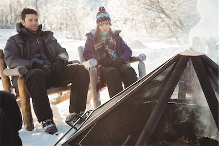 Skier couple sitting near the bonfire Stock Photo - Premium Royalty-Free, Code: 6109-08953176