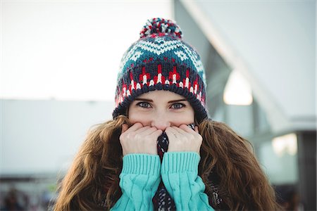 simsearch:6109-08953148,k - Beautiful woman in warm clothing covering her mouth with jumper Stock Photo - Premium Royalty-Free, Code: 6109-08953180