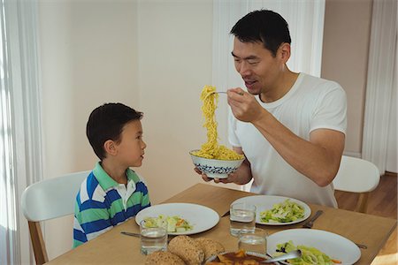 simsearch:6109-08953075,k - Father serving food to his son on dining table Stockbilder - Premium RF Lizenzfrei, Bildnummer: 6109-08953110