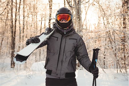 simsearch:6122-07706662,k - Man in ski wear holding skis on her shoulder Stock Photo - Premium Royalty-Free, Code: 6109-08953124