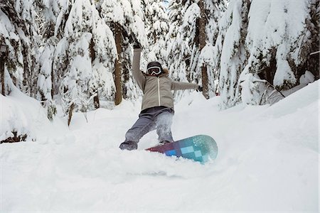 Woman snowboarding on snowy mountain Photographie de stock - Premium Libres de Droits, Code: 6109-08953250