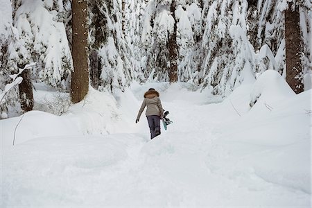 simsearch:6109-06195607,k - Female skier walking with ski on snowy landscape Photographie de stock - Premium Libres de Droits, Code: 6109-08953251