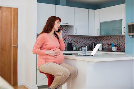 simsearch:6109-08537097,k - Pregnant woman talking on mobile phone in kitchen Stock Photo - Premium Royalty-Free, Code: 6109-08953257