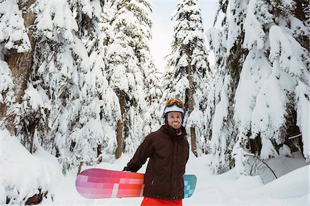 simsearch:6109-06195607,k - Man standing and holding a snowboard Photographie de stock - Premium Libres de Droits, Code: 6109-08953255