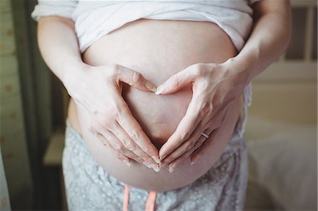 simsearch:400-05139317,k - Mid section of pregnant woman touching her belly in bedroom Stock Photo - Premium Royalty-Free, Code: 6109-08953277