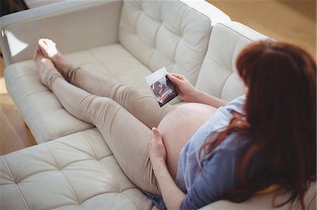 Pregnant woman relaxing on sofa and looking at sonography Stock Photo - Premium Royalty-Free, Code: 6109-08953283