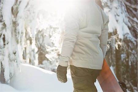 simsearch:6109-08944908,k - Woman standing and holding a snowboard on snow covered mountain Stock Photo - Premium Royalty-Free, Code: 6109-08953236