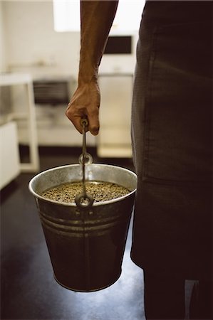 simsearch:649-06622991,k - Barista holding bucket full of green coffee beans in coffee shop Stock Photo - Premium Royalty-Free, Code: 6109-08953392