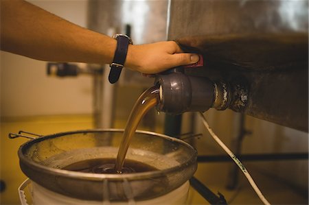 simsearch:6109-08953409,k - Male worker pouring honey from storage tank at apiary Foto de stock - Royalty Free Premium, Número: 6109-08953399