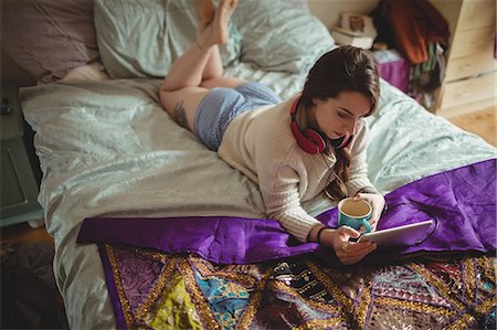 simsearch:6109-08689749,k - Woman using digital tablet while having coffee on bed Photographie de stock - Premium Libres de Droits, Code: 6109-08953327