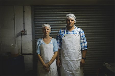 female factory worker looking at camera - Portrait of male and female workers standing in beekeeping factory Stock Photo - Premium Royalty-Free, Code: 6109-08953473