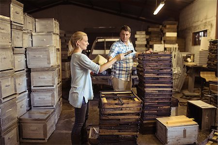 simsearch:6109-08953409,k - Male and female beekeepers working on hive frames in warehouse Foto de stock - Royalty Free Premium, Número: 6109-08953474