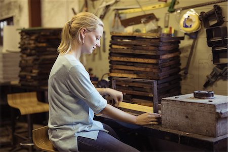 simsearch:6109-08953457,k - Side view of female beekeeper preparing hive frame in factory Stock Photo - Premium Royalty-Free, Code: 6109-08953479