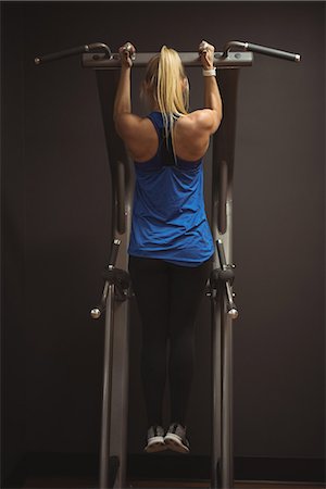 Rear view of fit woman exercising on a machine in the gym Stock Photo - Premium Royalty-Free, Code: 6109-08953489