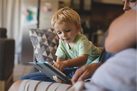 simsearch:6109-06005142,k - Boy using digital tablet by parents in living room at home Stock Photo - Premium Royalty-Free, Code: 6109-08953411