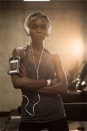 standing, headphones - Fit woman standing with arms crossed in the gym Foto de stock - Sin royalties Premium, Código: 6109-08953542
