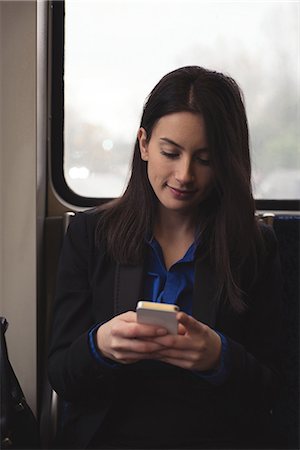 simsearch:6109-08581393,k - Woman using mobile phone while sitting by window in train Foto de stock - Sin royalties Premium, Código: 6109-08953645