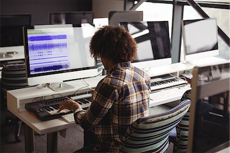 simsearch:6109-08953686,k - Male audio engineer working on digital editing screen in recording studio Stock Photo - Premium Royalty-Free, Code: 6109-08953666