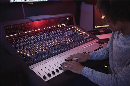 Male audio engineer using sound mixer in recording studio Stock Photo - Premium Royalty-Free, Code: 6109-08953668