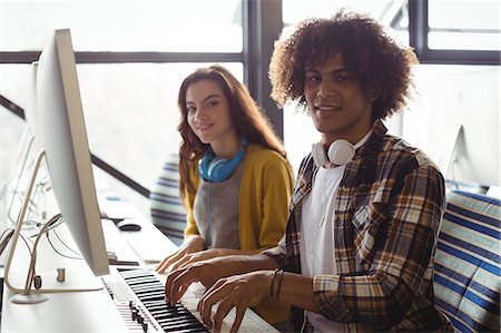 simsearch:6109-08953791,k - Portrait of audio engineers playing electric keyboard in recording studio Photographie de stock - Premium Libres de Droits, Code: 6109-08953677