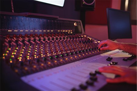 simsearch:6109-08953686,k - Hands of male audio engineer using sound mixer in recording studio Stock Photo - Premium Royalty-Free, Code: 6109-08953674
