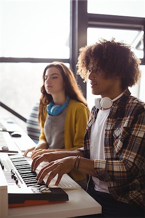 pictures of musicians with headphones - Audio engineers playing electric keyboard in recording studio Stock Photo - Premium Royalty-Free, Code: 6109-08953675