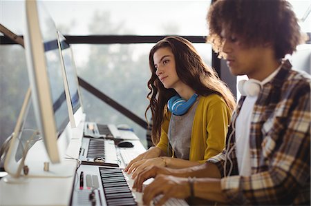 enregistrement - Audio engineer playing electric keyboard in recording studio Foto de stock - Sin royalties Premium, Código: 6109-08953678