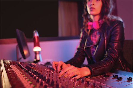 Female audio engineer using sound mixer in recording studio Photographie de stock - Premium Libres de Droits, Code: 6109-08953687