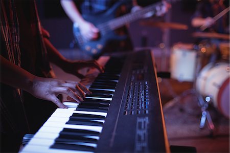 Mid section of musician playing electronic piano in recording studio Stock Photo - Premium Royalty-Free, Code: 6109-08953720