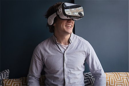 Happy man using virtual reality headset in Café Stock Photo - Premium Royalty-Free, Code: 6109-08953888