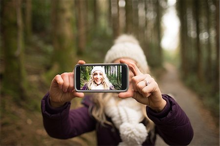 stylish people taking photos - Woman taking selfie in the forest Stock Photo - Premium Royalty-Free, Code: 6109-08953833