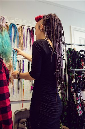 simsearch:6109-08952901,k - Female shop owner showing dreadlocks to a customer in shop Stock Photo - Premium Royalty-Free, Code: 6109-08928353
