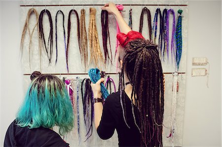 simsearch:6109-08952901,k - Female shop owner showing dreadlocks to a customer in shop Stock Photo - Premium Royalty-Free, Code: 6109-08928354