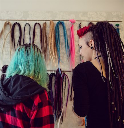 Female shop owner showing dreadlocks to a customer in shop Foto de stock - Sin royalties Premium, Código: 6109-08928355