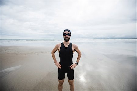 simsearch:6109-08928512,k - Athlete in swimming goggles standing with hand on hip at beach Stock Photo - Premium Royalty-Free, Code: 6109-08928453