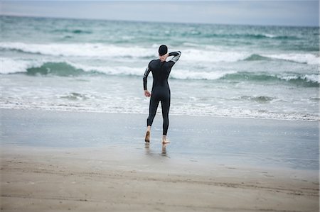 simsearch:6109-08928512,k - Rear view of athlete in wet suit standing on beach Stock Photo - Premium Royalty-Free, Code: 6109-08928460