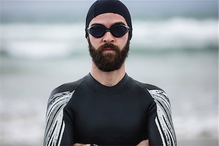 simsearch:6109-08928446,k - Athlete in wet suit standing with his arms crossed on beach Photographie de stock - Premium Libres de Droits, Code: 6109-08928467