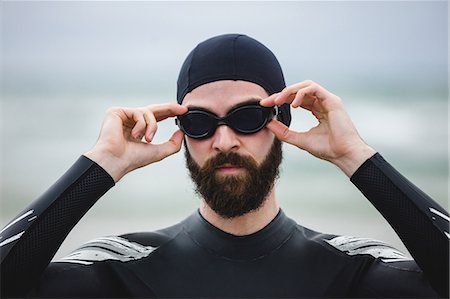 simsearch:6109-08928512,k - Athlete in wet suit wearing swimming goggles on beach Stock Photo - Premium Royalty-Free, Code: 6109-08928466
