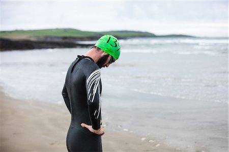 simsearch:6109-06195368,k - Tired athlete leaning over to catch his breath on the beach Stock Photo - Premium Royalty-Free, Code: 6109-08928488