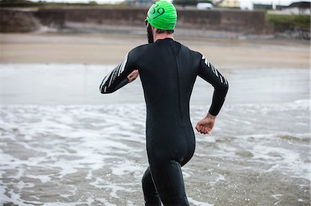 simsearch:6109-08928446,k - Rear view of athlete running towards the beach Photographie de stock - Premium Libres de Droits, Code: 6109-08928497