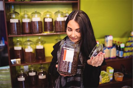 simsearch:6109-08928615,k - Beautiful woman smelling jar of coffee beans in shop Photographie de stock - Premium Libres de Droits, Code: 6109-08928590