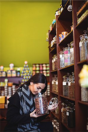 simsearch:6109-08928615,k - Beautiful woman smelling a jar of spice in shop Photographie de stock - Premium Libres de Droits, Code: 6109-08928595