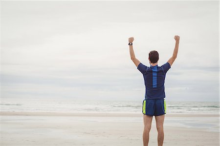 simsearch:6109-06195368,k - Rear view of athlete standing on the beach with his hands raised Stock Photo - Premium Royalty-Free, Code: 6109-08928509