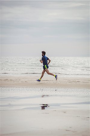 simsearch:693-07672615,k - Athlete running along the beach on a sunny day Fotografie stock - Premium Royalty-Free, Codice: 6109-08928515